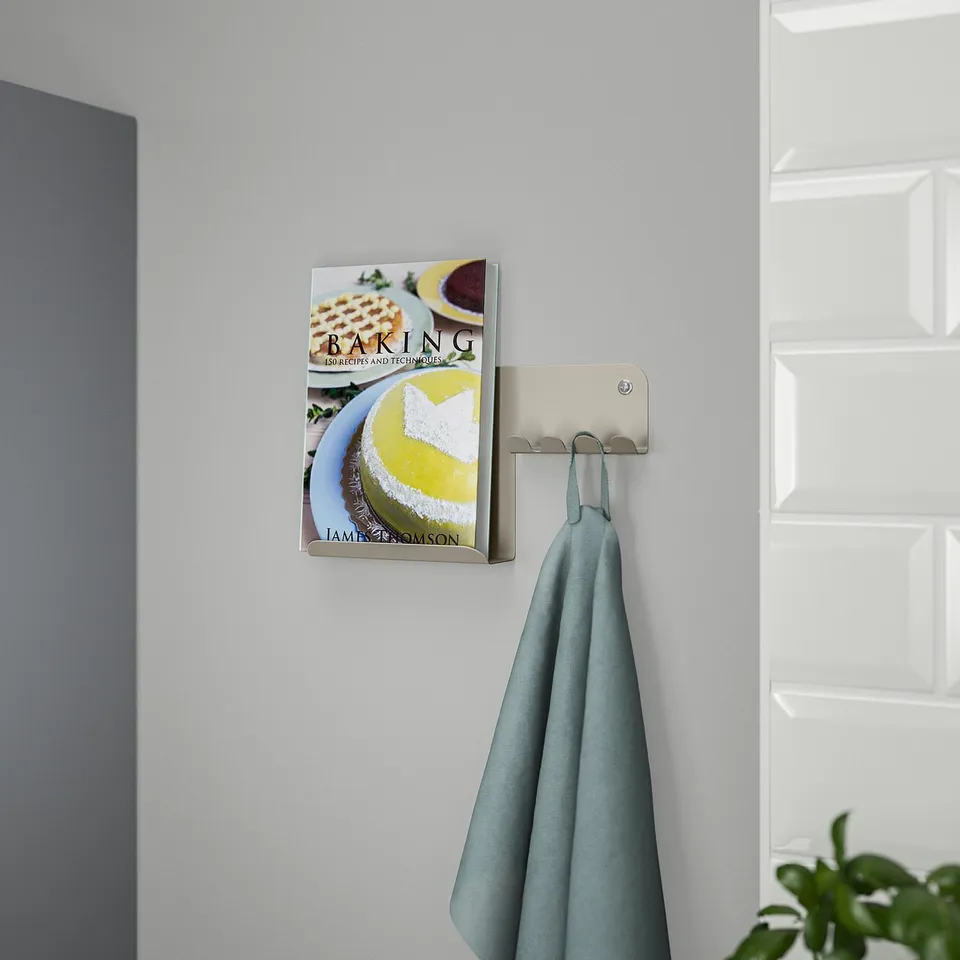 Wall-mounted organiser holds book and cloth; keeps items accessible.