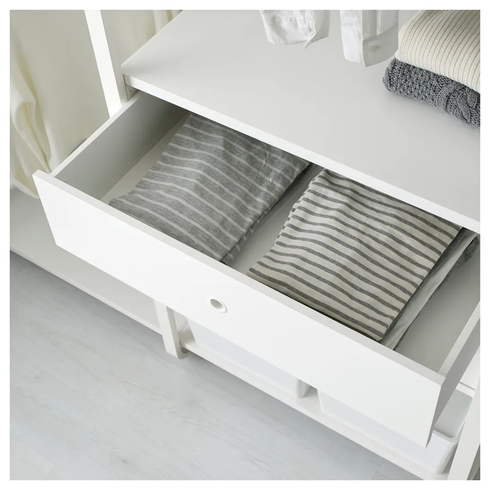 Open white drawer unit with two separated sections filled with folded striped towels.