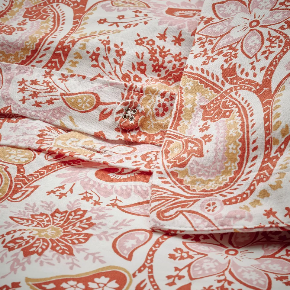 Folded paisley print duvet cover with button closure, made of breathable cotton and viscose blend.