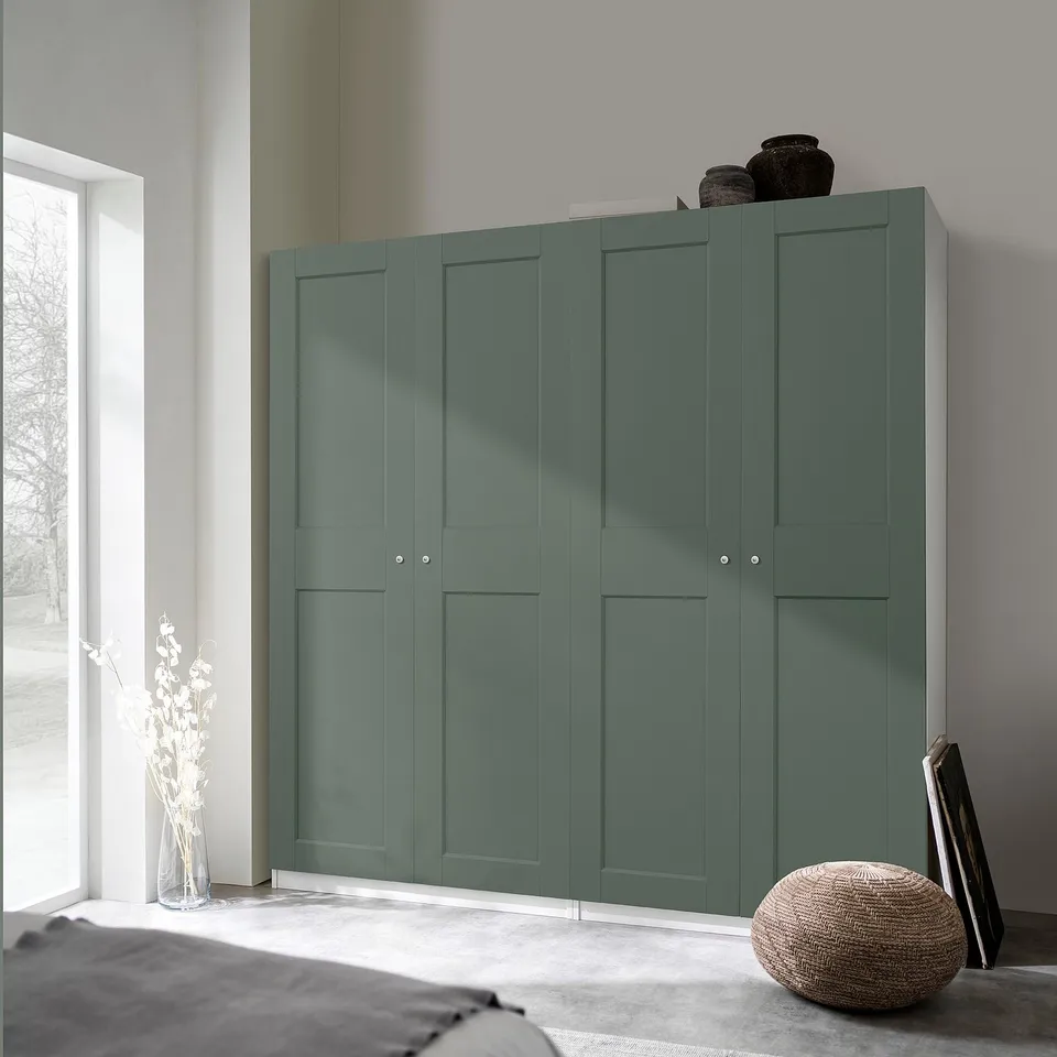 Modern green PAX wardrobe fits corner, tall with vases on top, near large window.