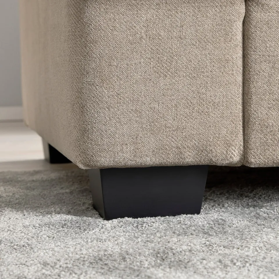 Close-up of cosy, thick-pile rug beneath grey sofa, showcasing softness and quality.