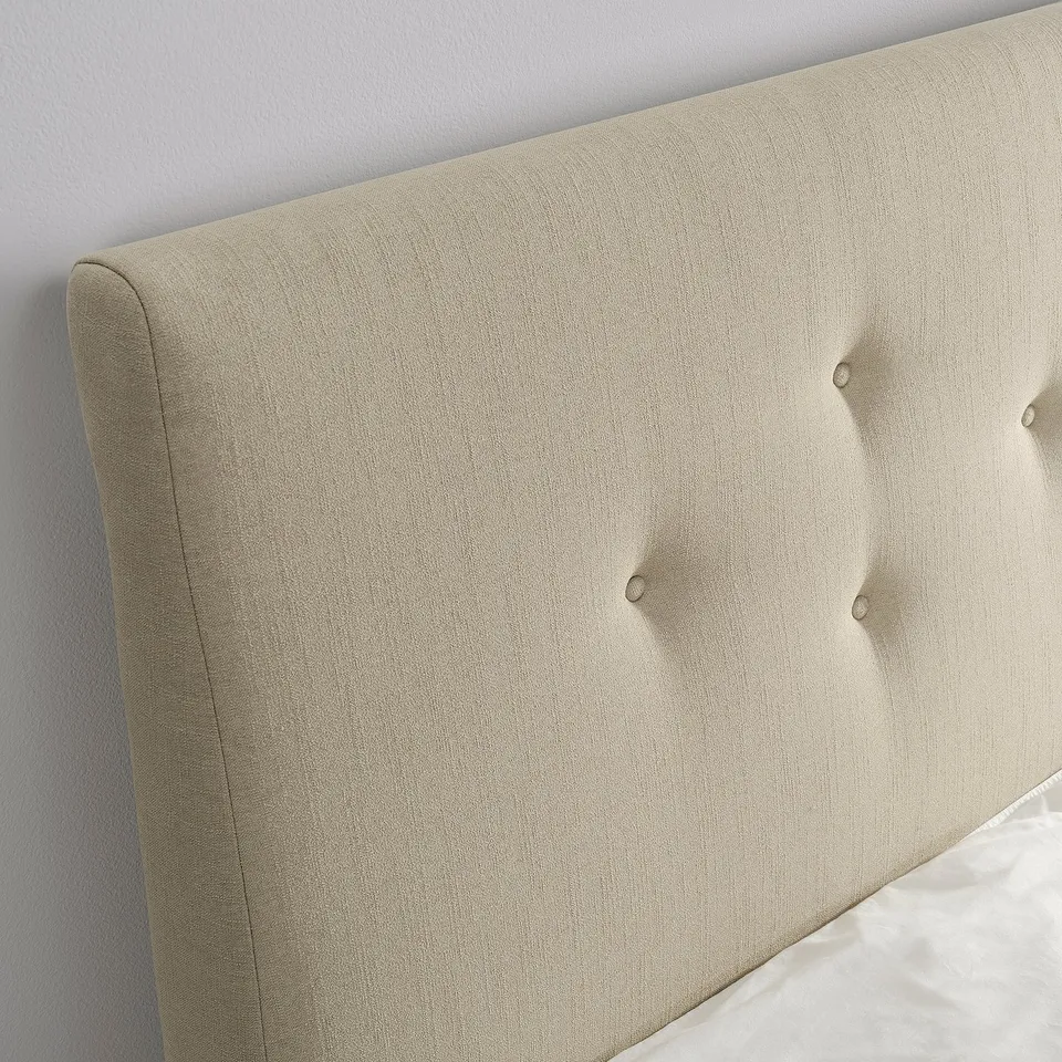 Close-up of beigebuided IDANÄS headboard, showing plush tufted design and quality fabric.