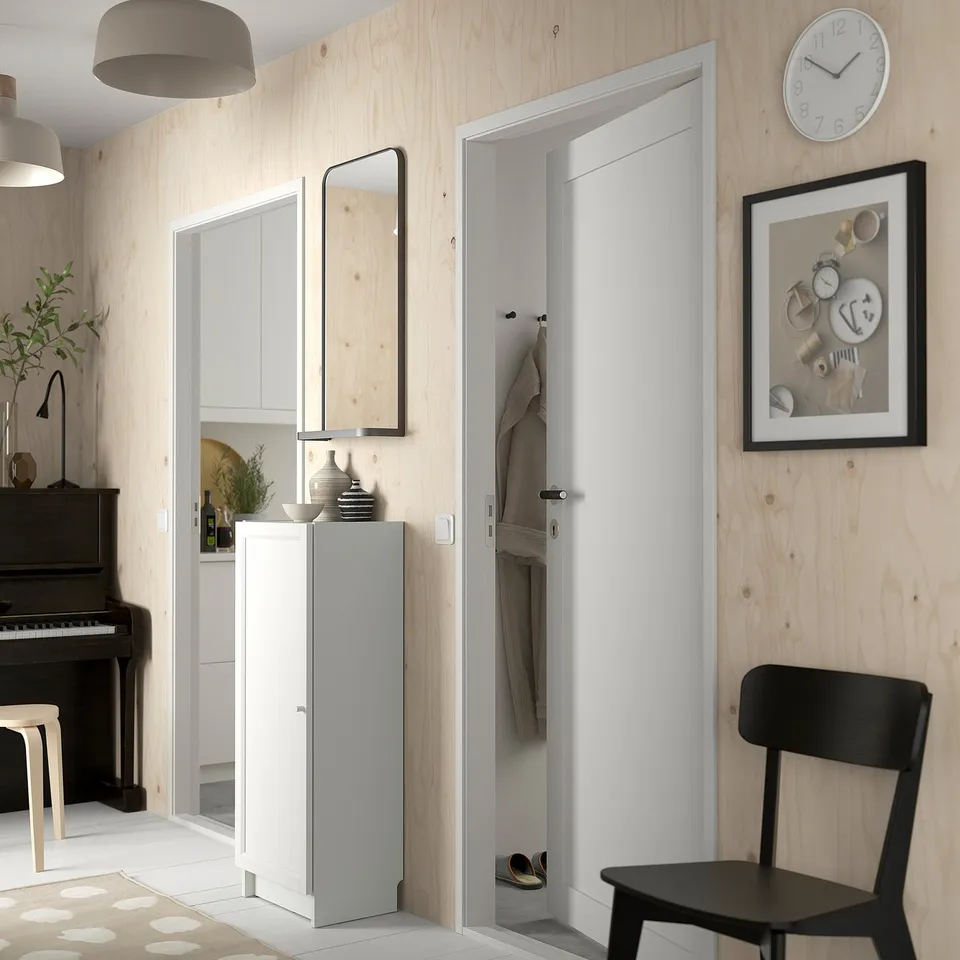 Modern hallway with BILLY white storage unit, wooden walls, black piano, black chair, and clock.