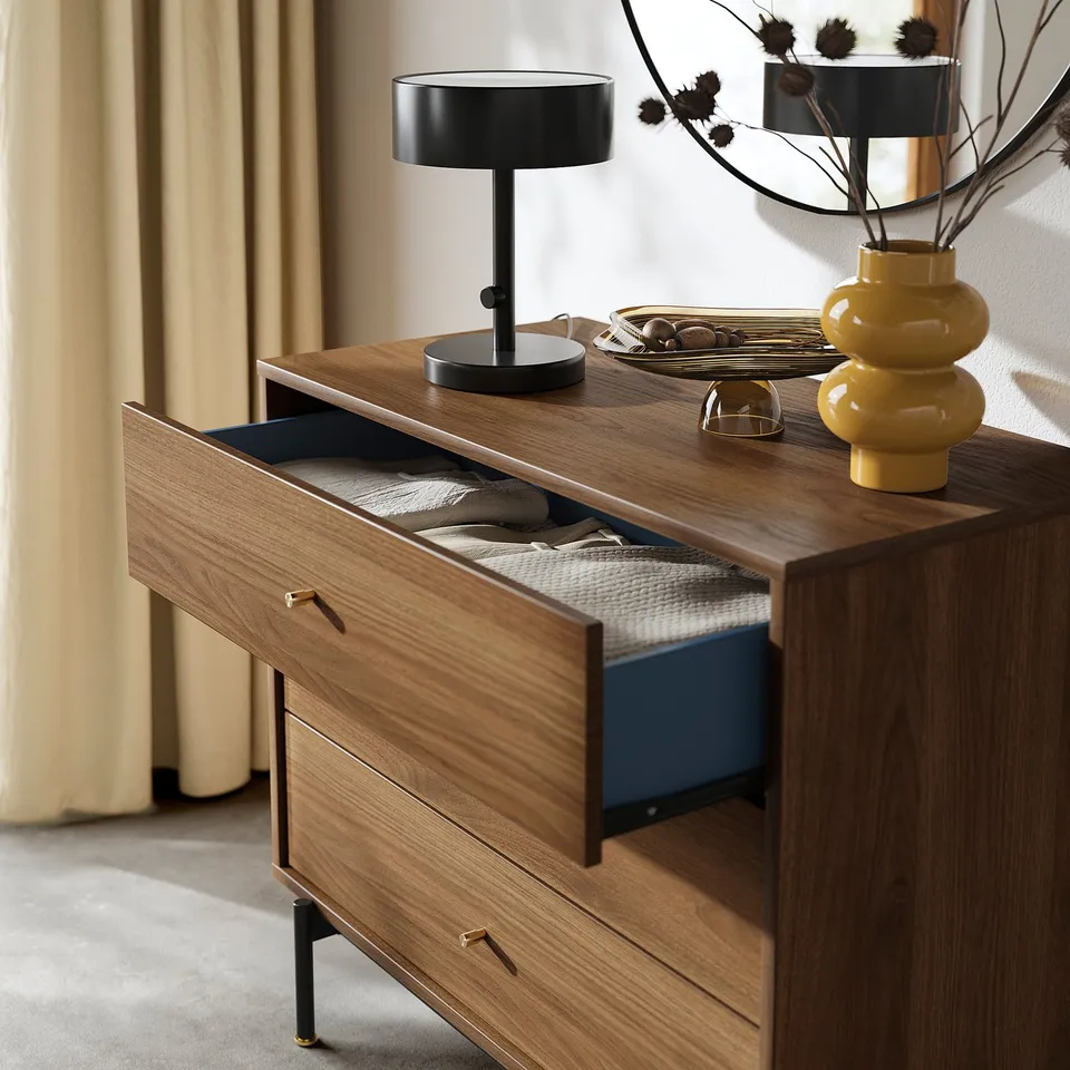 Mid-century wooden chest, 3 drawers, gold handles, black legs, blue interiors. Top: lamp, vase, tray.