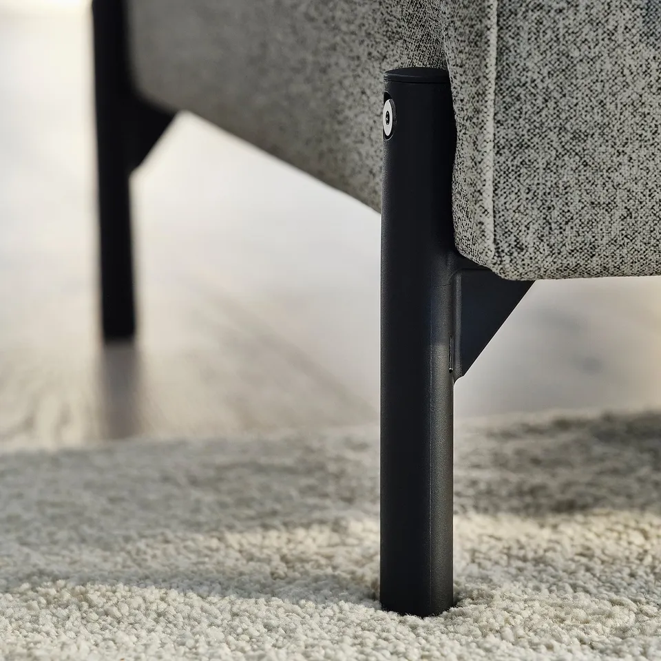 Close-up of stylish sofa leg, showing quality design & sturdy material, matching textured fabric.