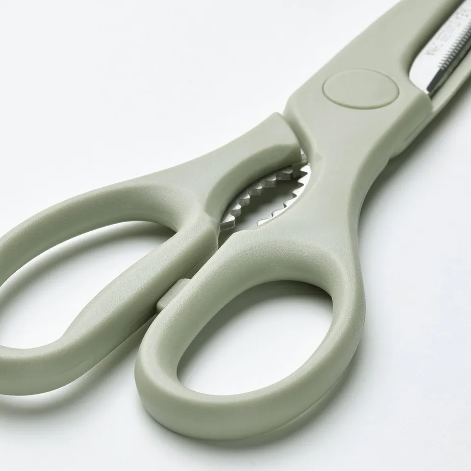 Green scissors with stainless steel blades and serrated bottle opener in handle, designed for both right and left-handed users.
