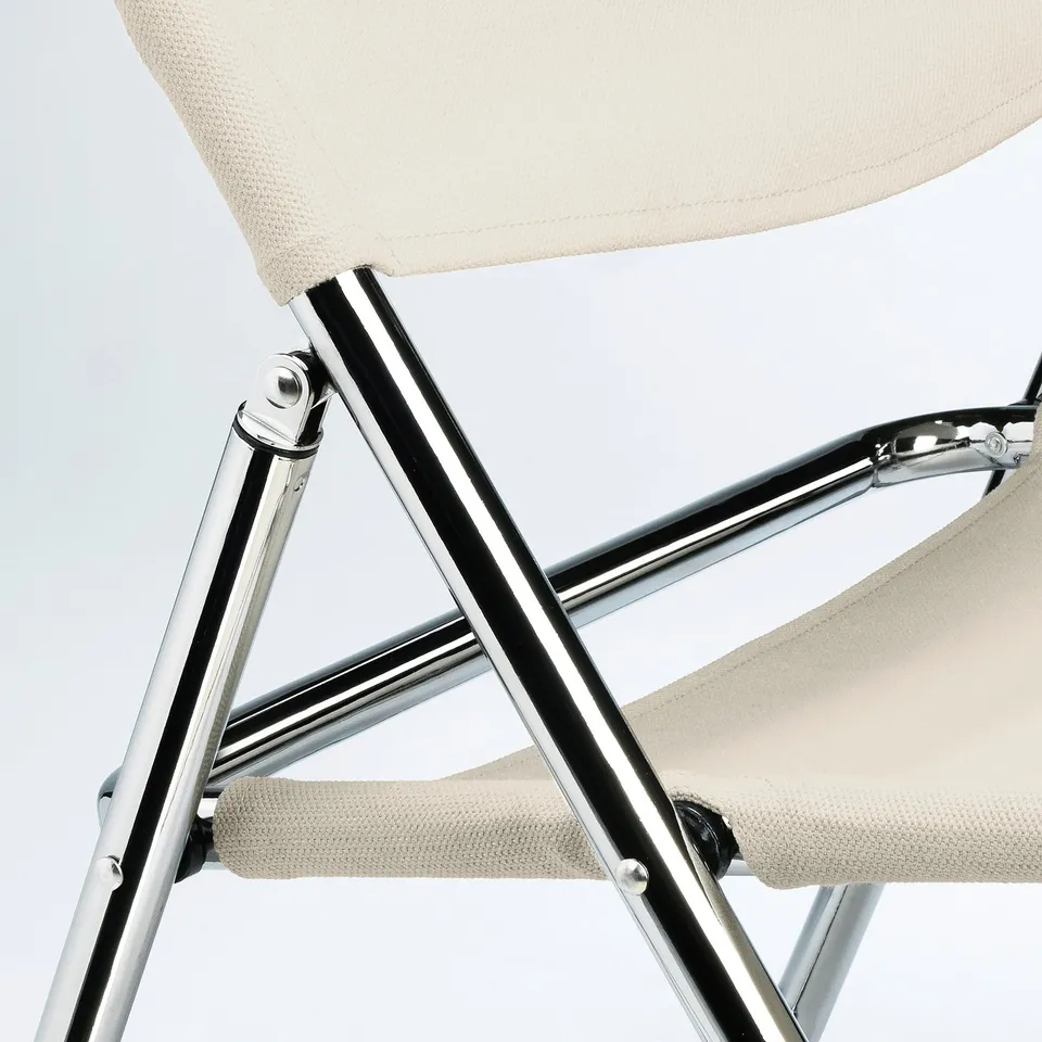 A modern, beige folding chair with chrome-plated steel frame, featuring sleek, sturdy design.