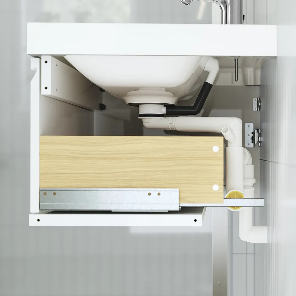 Under-sink cabinet with drawer, wall-mounted, showing pipes and plumbing.