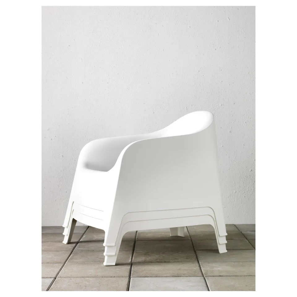 White plastic stackable outdoor armchair with drain hole in seat, ideal for outdoors.