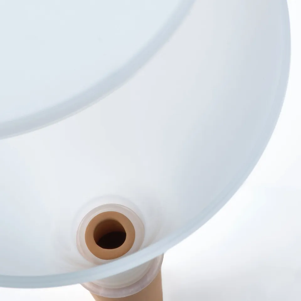 White self-watering plant insert close-up. Terracotta tube for slow water release and clear base for water visibility.