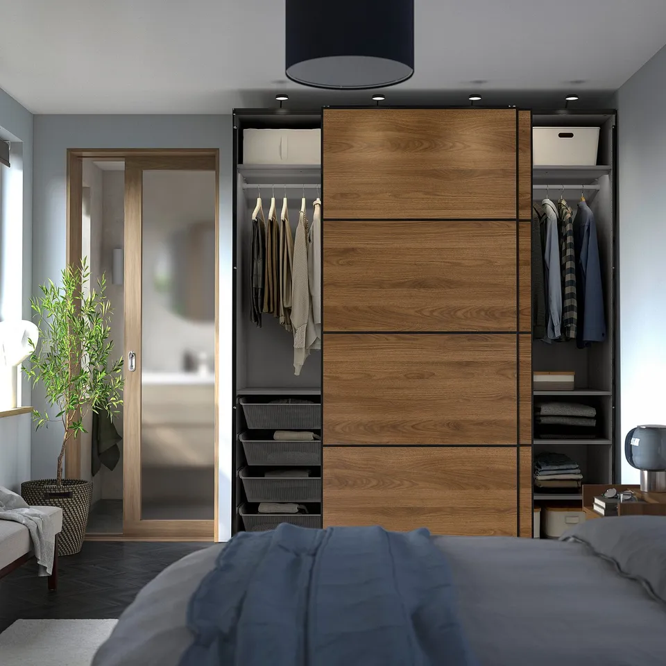 Modern bedroom with a large PAX wardrobe featuring sliding doors, shelving, and hanging clothes.