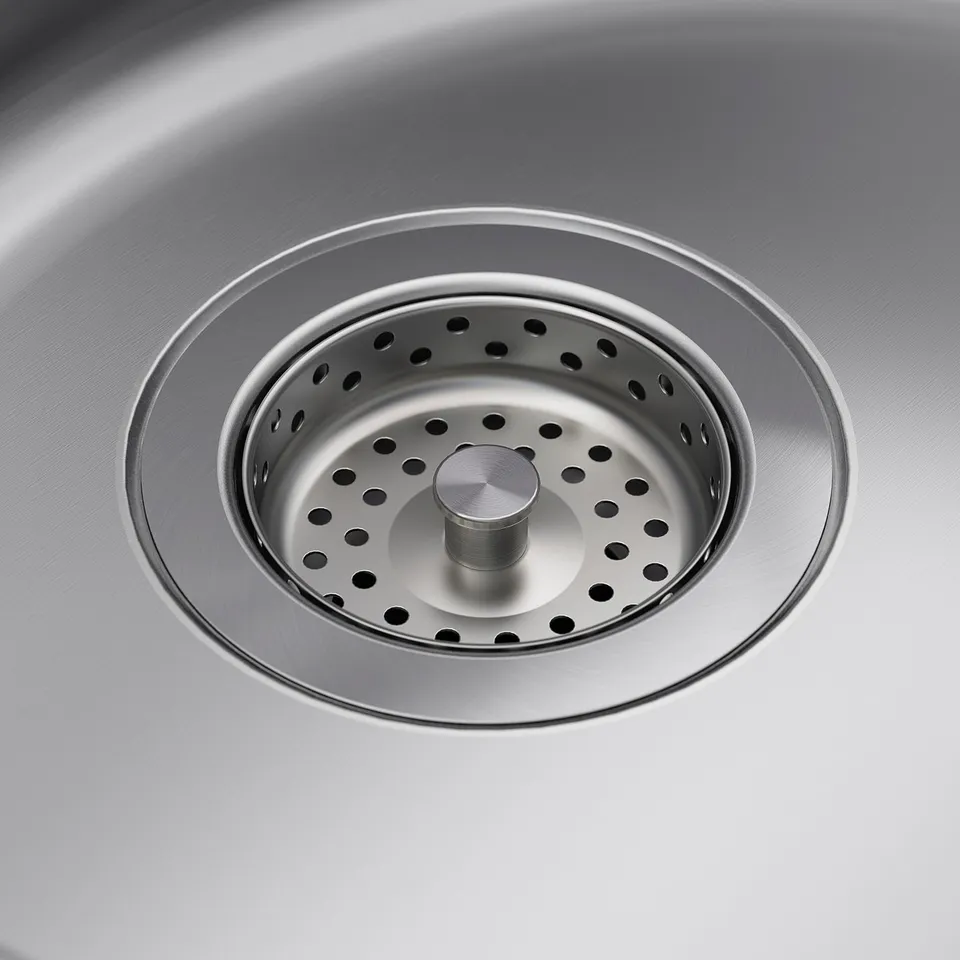 Stainless steel sink drain with strainer in centre, showcasing quality and durability.