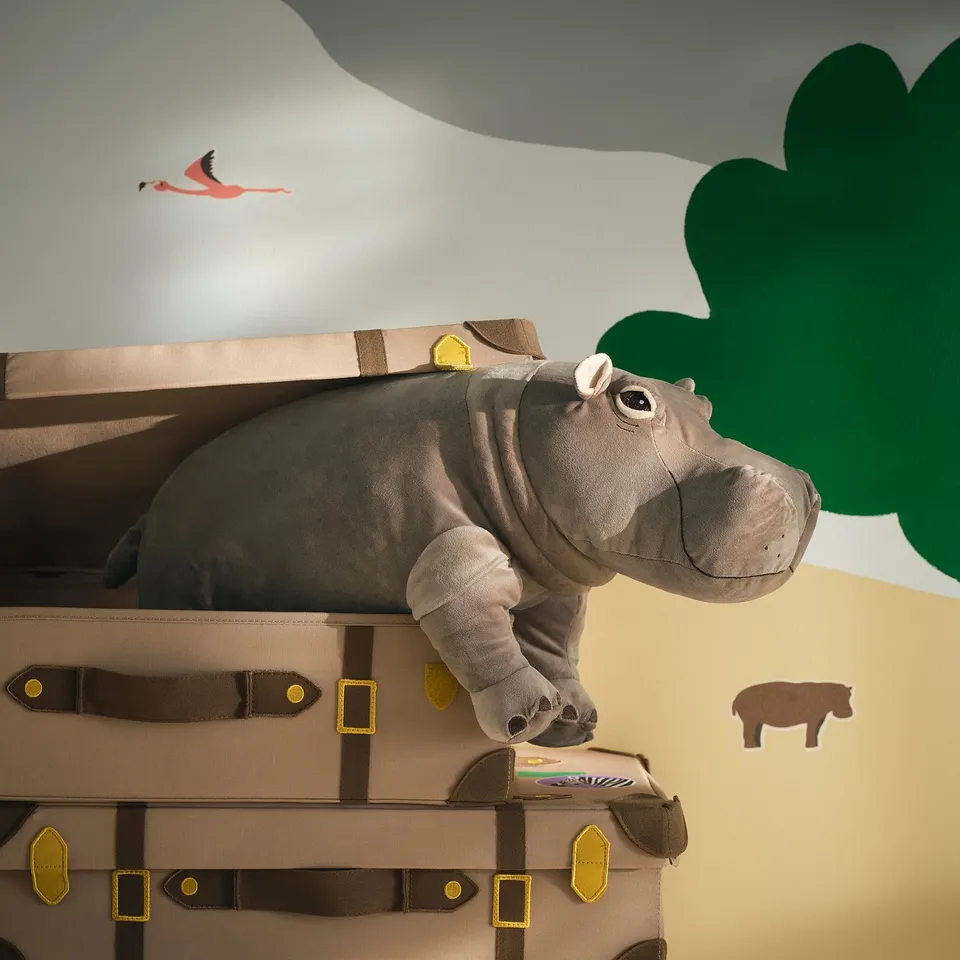 SANDLÖPARE stuffed grey hippo on brown trunk, larger than flamingo sticker.
