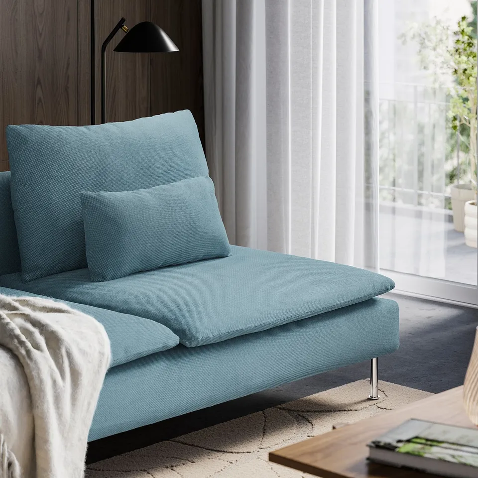 Modern light blue sofa with high legs near large window, sheer curtains, cosy & airy.