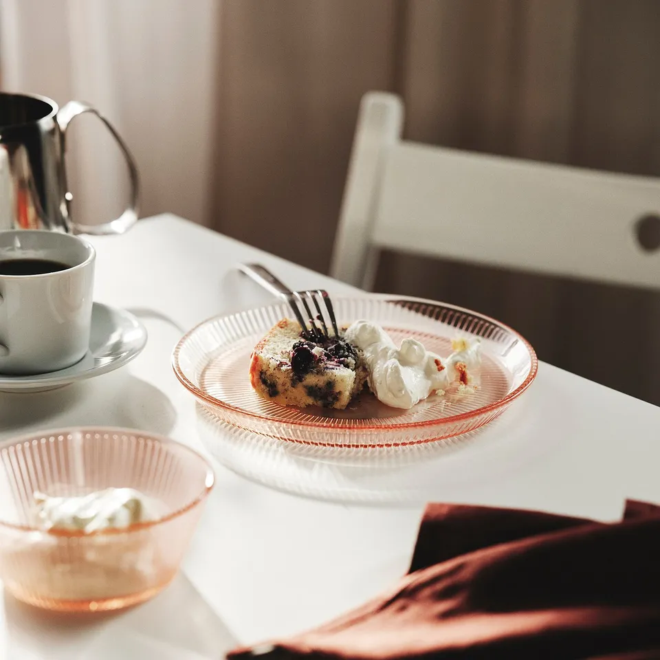 Breakfast setup: pastry with berries and cream, coffee, and cream pitcher.
