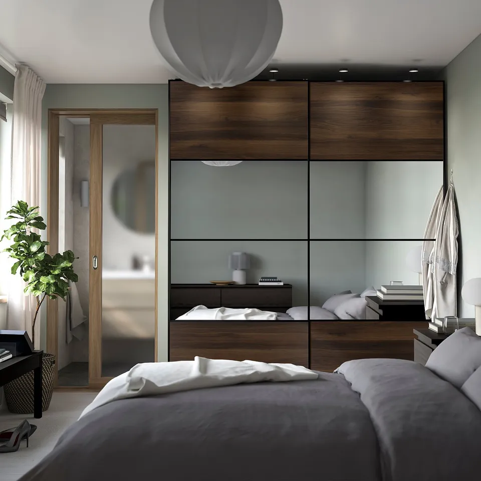Modern bedroom with AULI dark brown glass sliding door, mirrored effect, slim frames, matching furniture, plant, soft lighting.