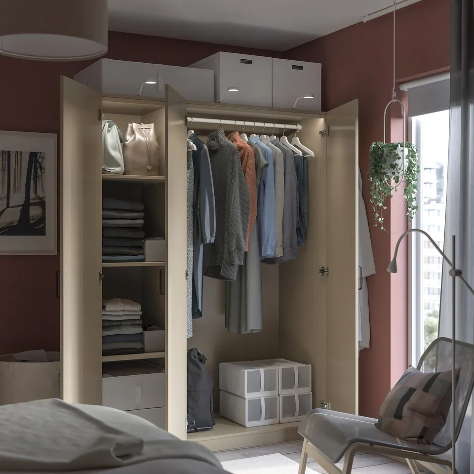 Open wardrobe with clothes, including jackets, and accessories, featuring shelves and boxes.