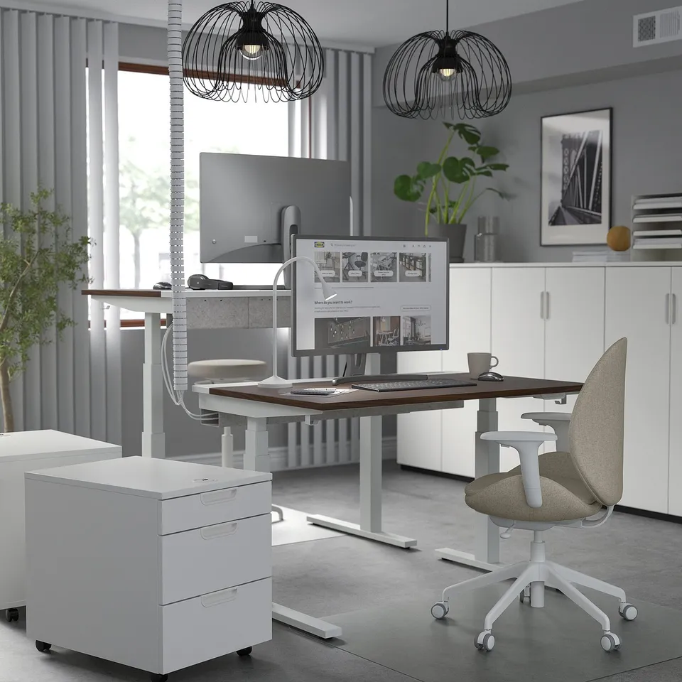Modern office: MITTZON sit-stand desk, ergonomic chair, white cabinets, large monitor, pendant lights.