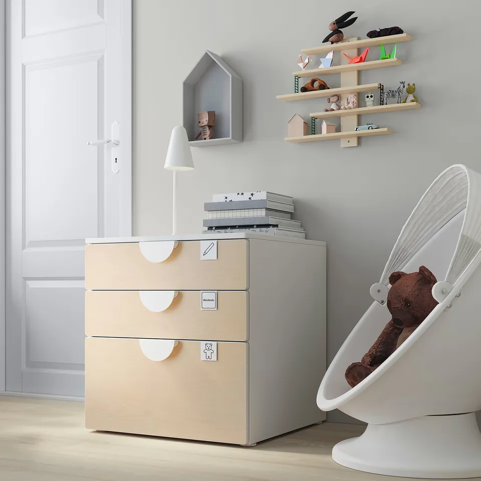 Modern kids room with light wood SMÅSTAD chest, white rocker, books, toys, and lamp.
