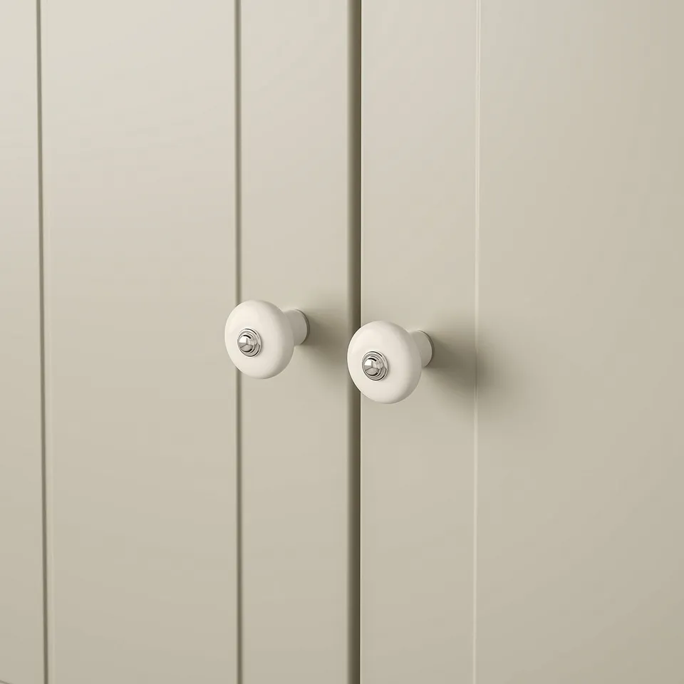 White knobs with chrome on beige cabinets.