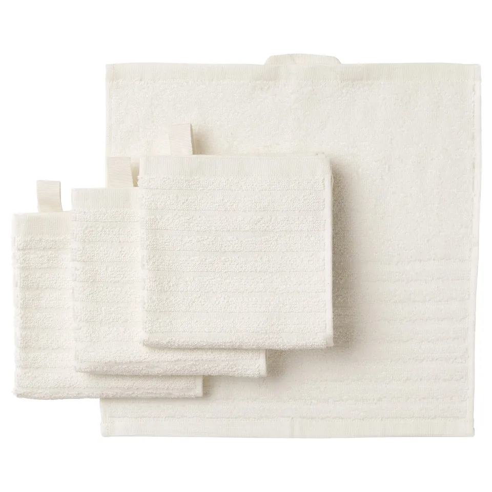 A set of white VÅGSJÖN towels, featuring a combination of solid terry and striped sections, made from 100% cotton, neatly folded and stacked.