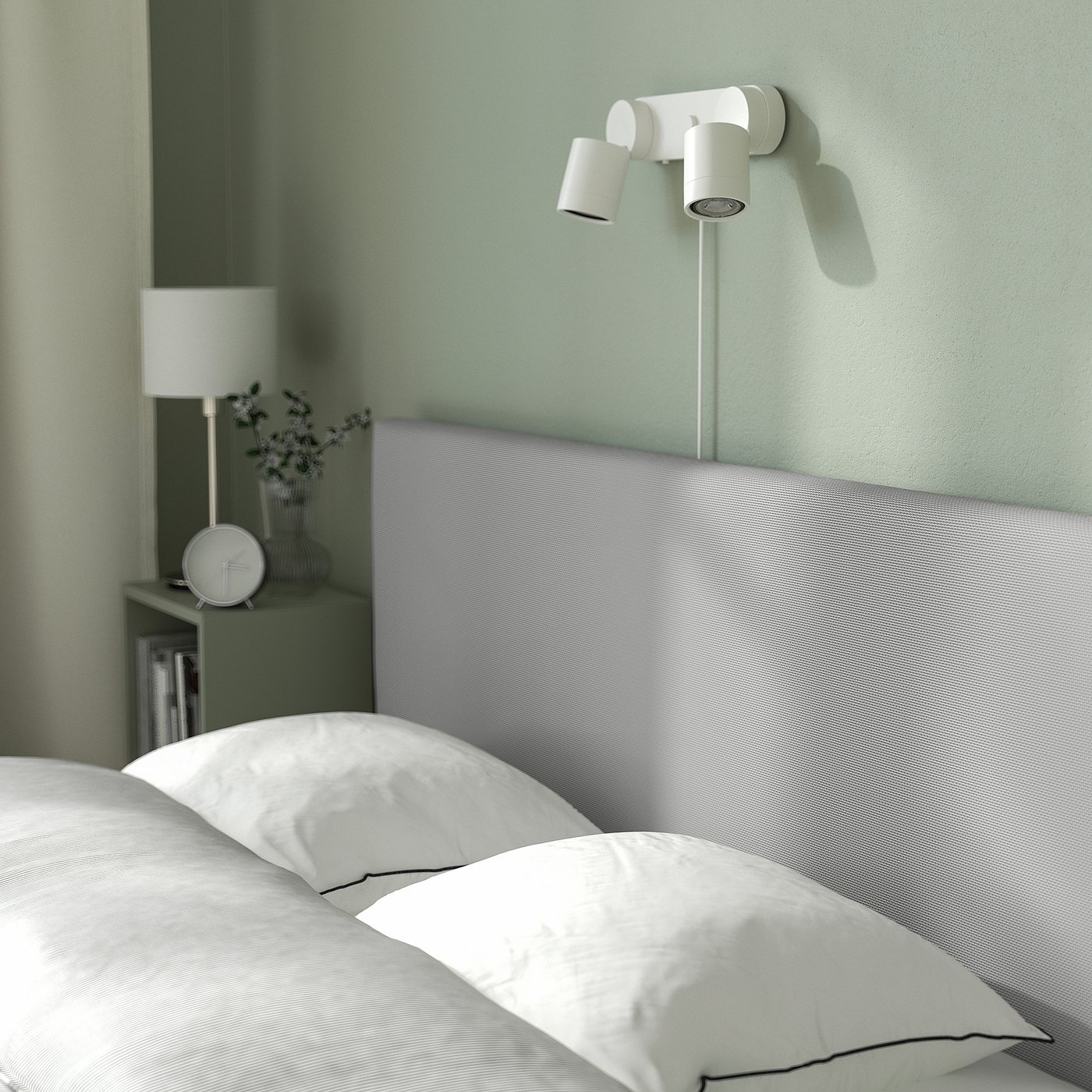 Modern bed with padded headboard, storage, and dual spotlights on green wall. Crisp white bedding for a minimalist look.