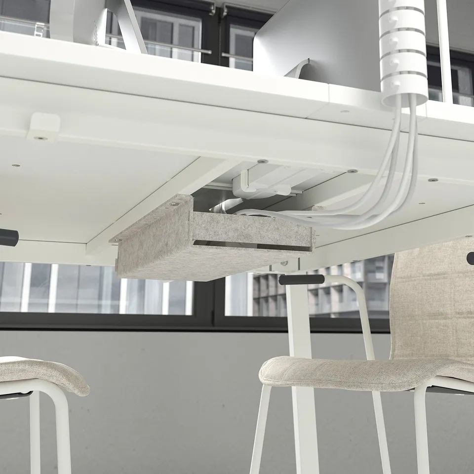 A modern office setup with a white, adjustable-height table and chairs, designed for conferences.