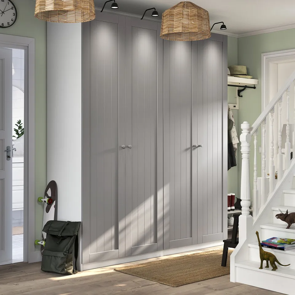 Grey PAX wardrobe in lit hallway, between doorway and staircase.