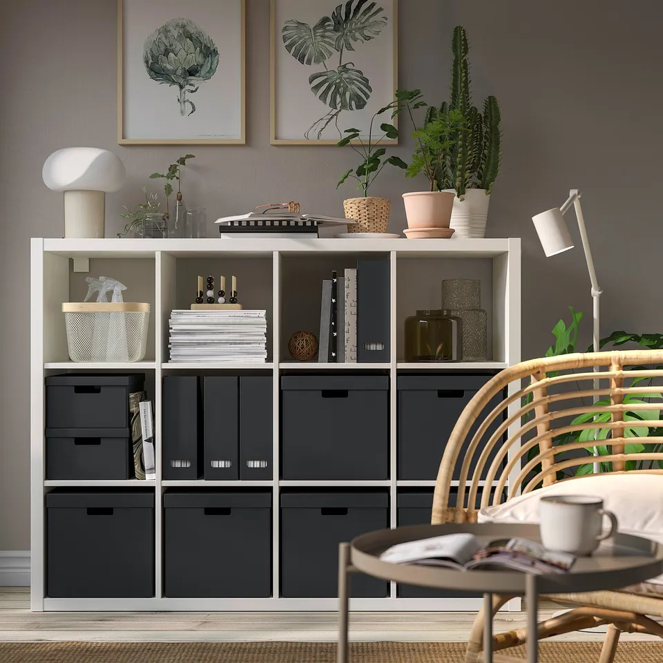 Cosy living space with FJÄDERHARV boxes on kallax shelf, decorated with plants and art.
