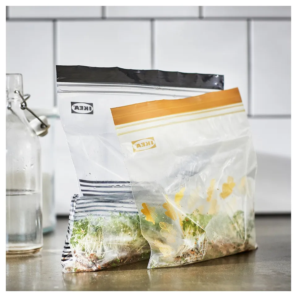 Stacked ISTAD reusable food storage bags on a countertop with visible contents.