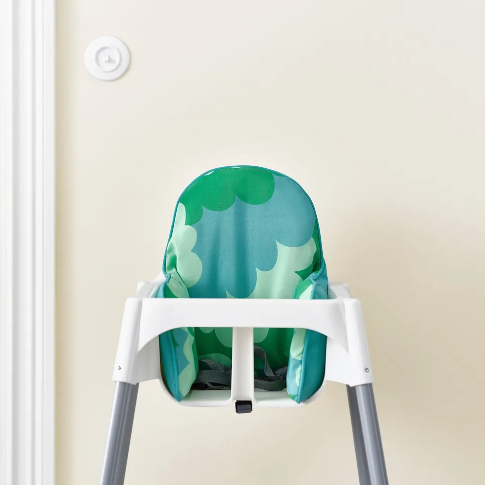 Highchair cushion for infant support, featuring geometric pattern, easy-to-clean cover, and secure seating, ideal for ages 6 months and up.