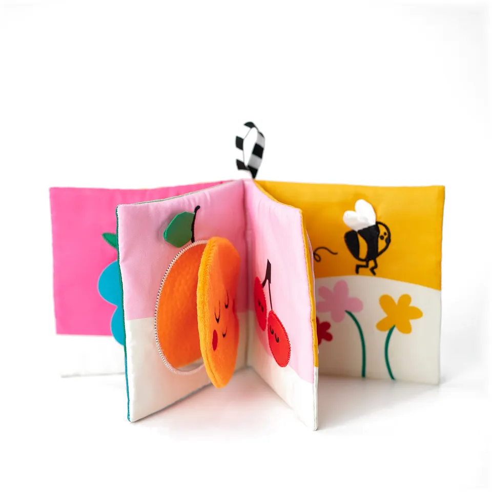 Fabric baby book with embroidered fruits, flowers, textures, & teether.