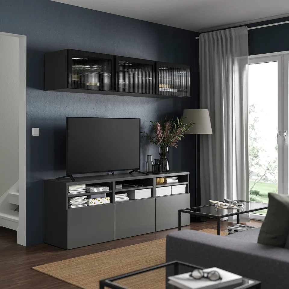 Modern living room with grey FÄLLSVIK unit, flat screen tv, grey curtains, and wooden floor.