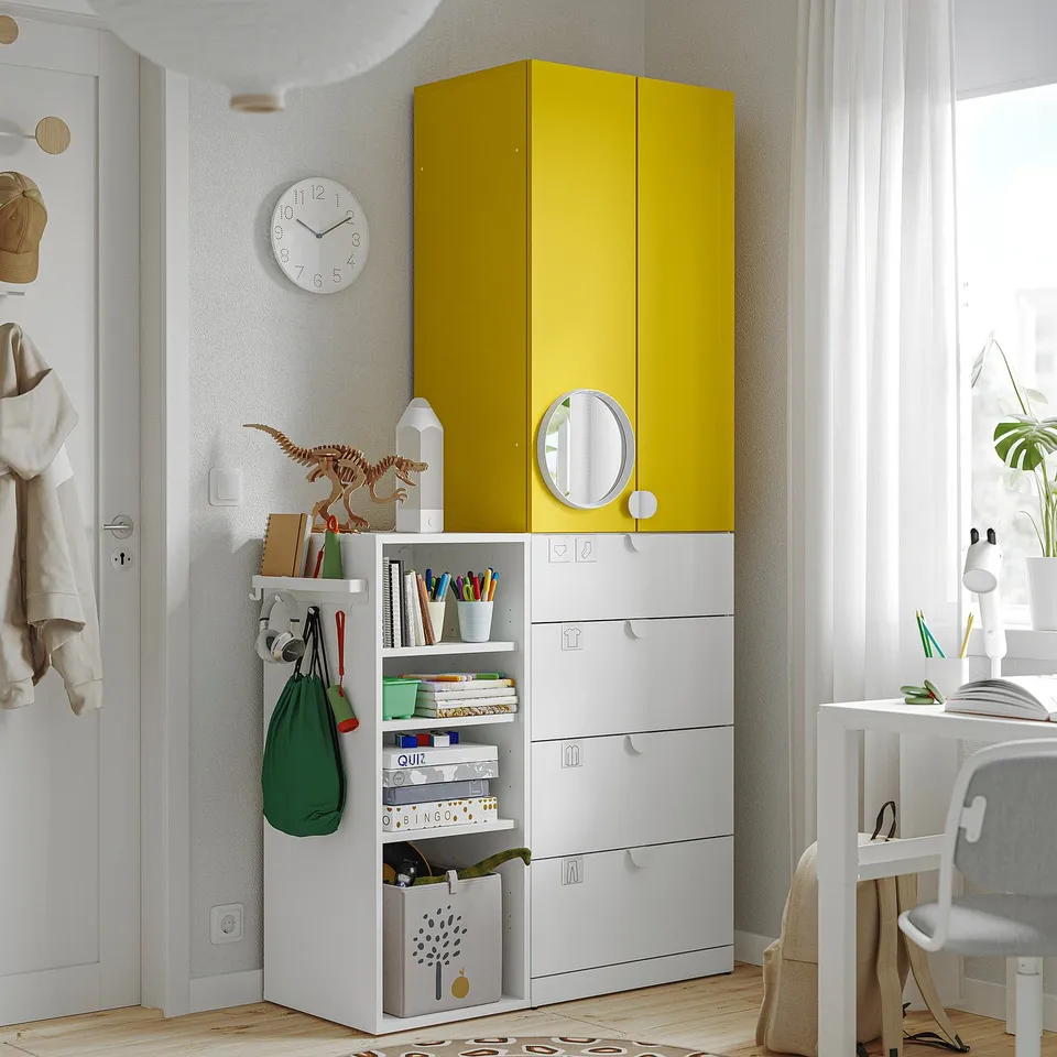 Yellow-white storage unit, tall, wardrobe, drawers, beside window, similar size to desk, with shelves and containers.