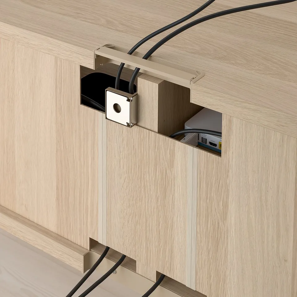 A wall-mounted tv bench with integrated cable management. Cables are organised and fed through a designated outlet in the wooden panel.