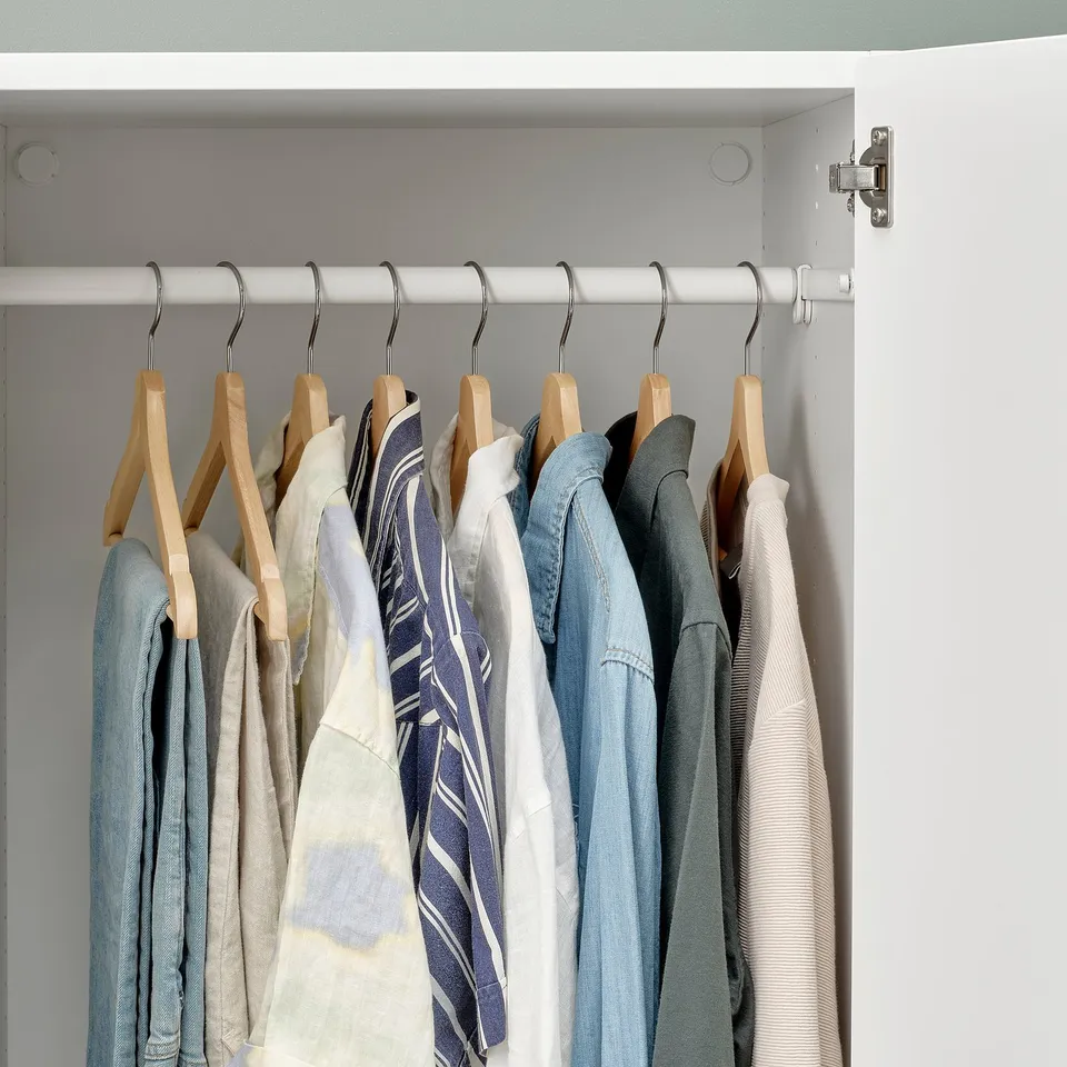 Organised closet with wooden hangers holding shirts and jackets.