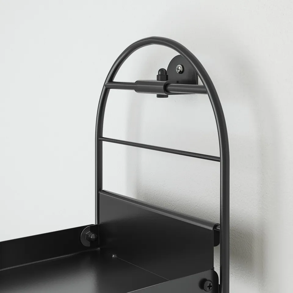 Black metal plant stand with arched handle, mounted vertically on wall. Designed for holding plants or small items. Modern and sturdy construction.