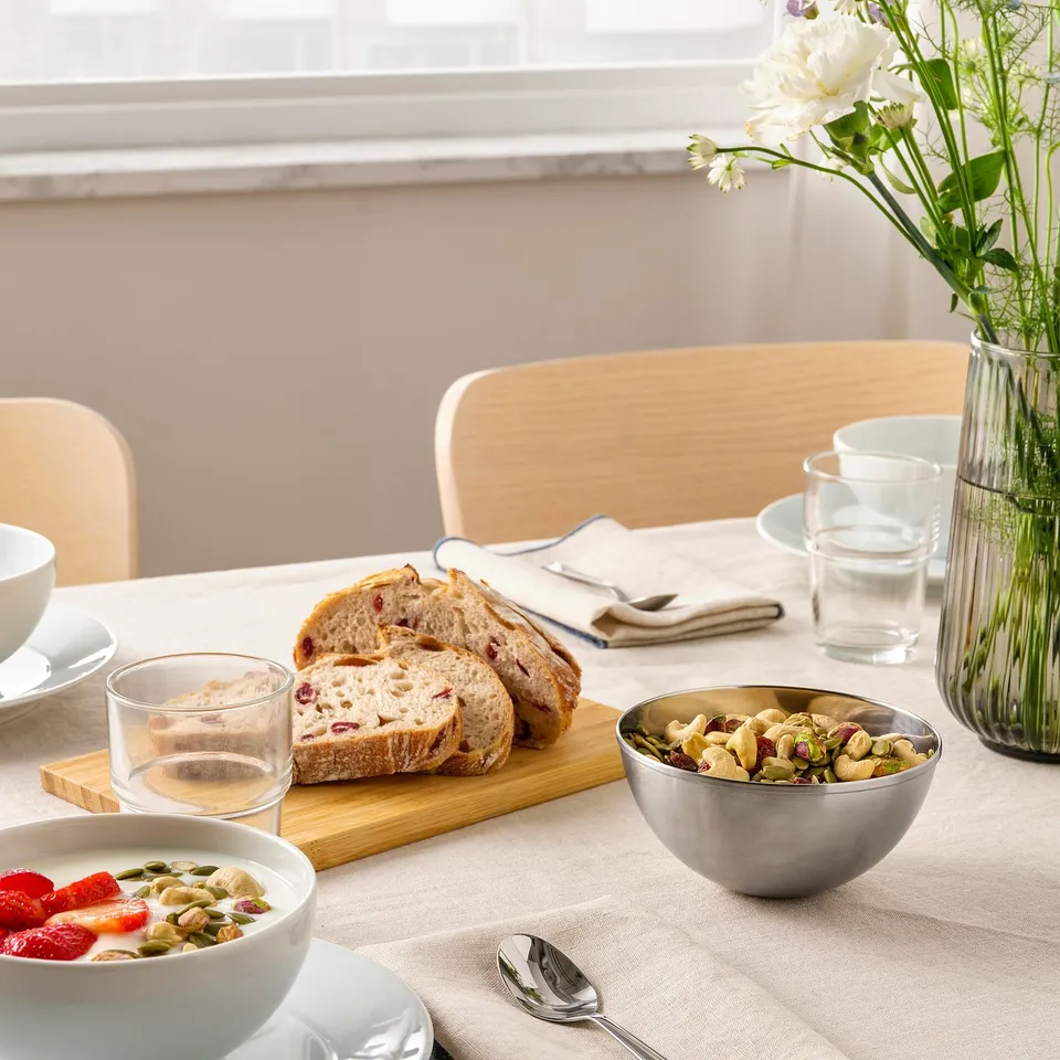 Table set with bowls, bread, and glasses; simple, functional decor.