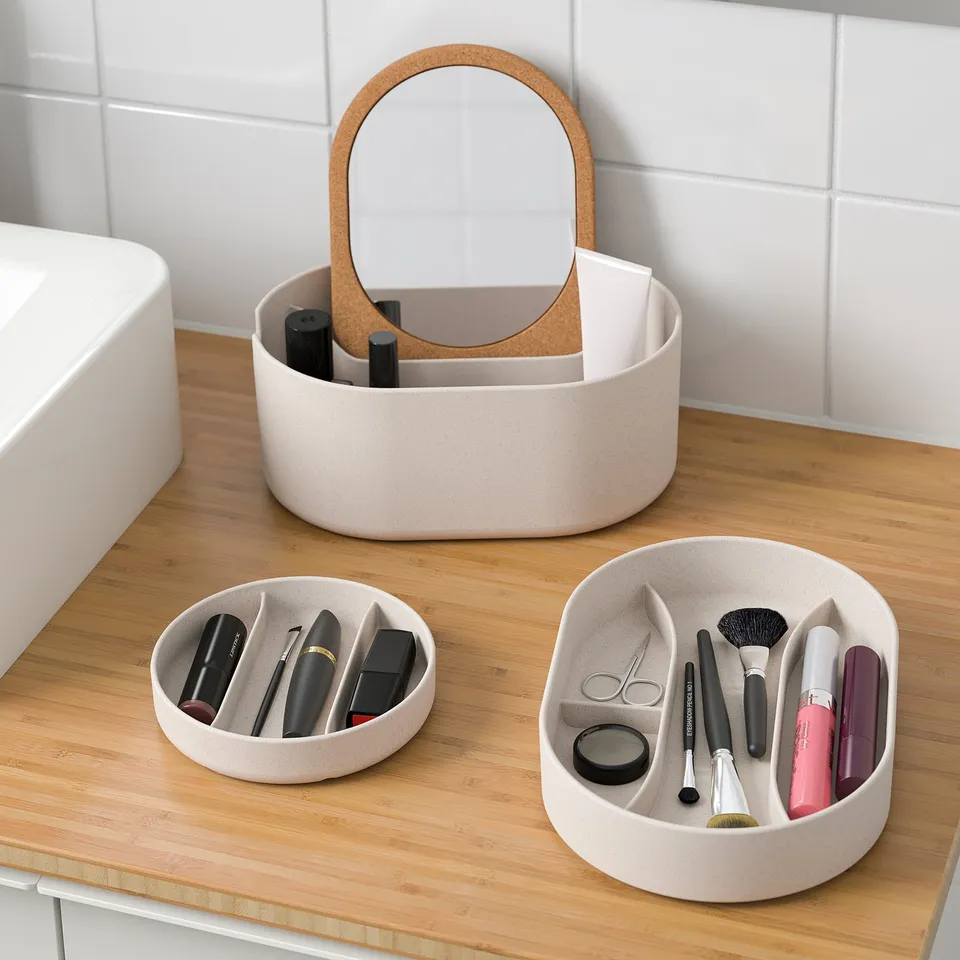 Vanity organiser with makeup, mirror & beauty tools on counter.