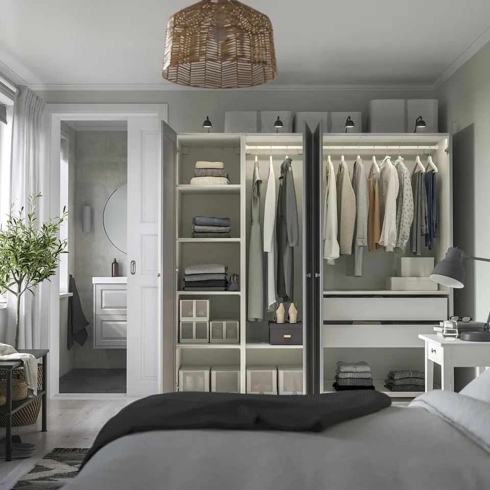 Modern bedroom with PAX wardrobe, clothes, lighting, partial bed, and en suite doorway.