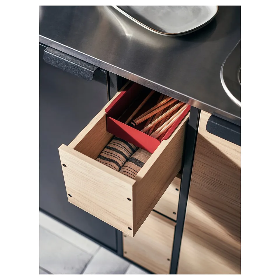 Open kitchen drawer, light wood, red organiser, stainless steel counter