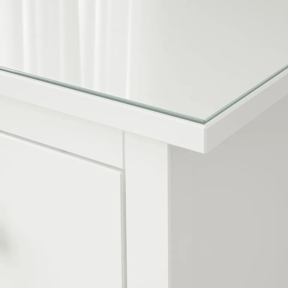 Clear, tempered glass surface, seamlessly mounted on a white cabinet, reflecting light.