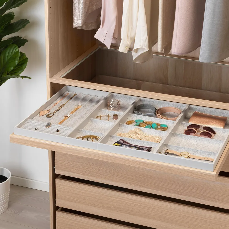 Organised drawer with compartments for jewellery, belts, and accessories. Soft felt lining protects items. Pulls out smoothly with integrated damper.