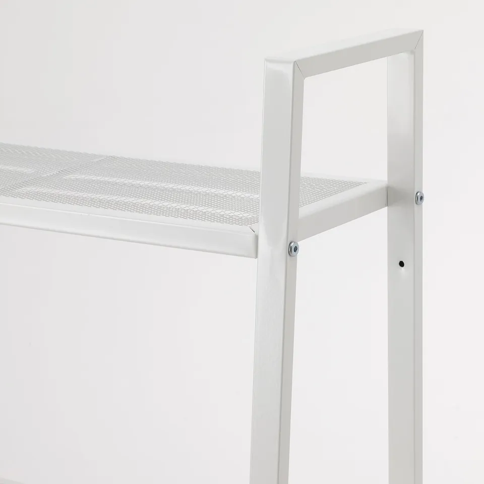 A close-up of a modern, white metal shelf with a perforated steel surface, secured by visible screws.