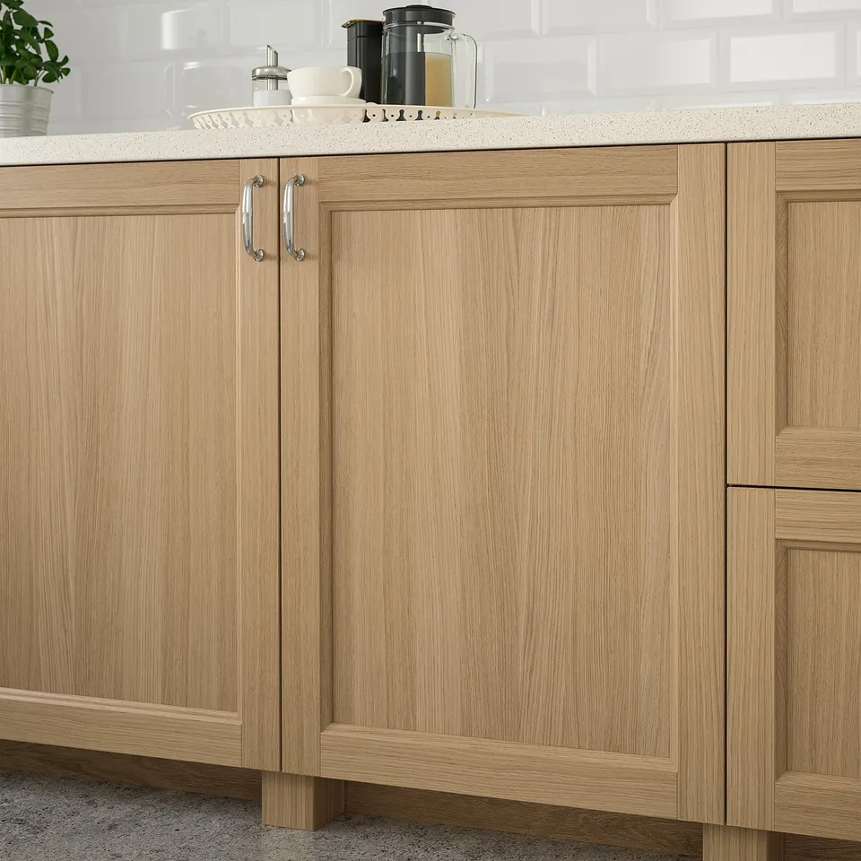 Wooden kitchen cabinets with a coffee maker and cups.