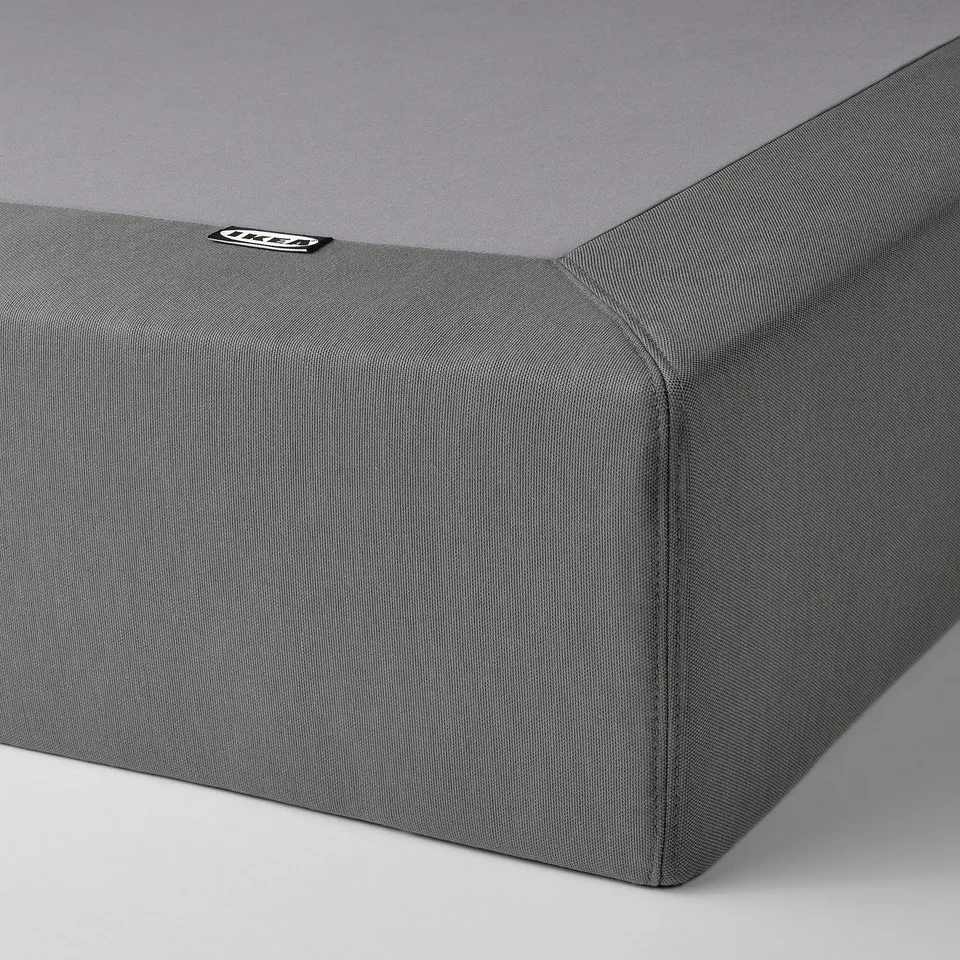 Close-up of a plush, grey LYNGÖR bed base; soft fabric cover, robust design, rigid slats visible.