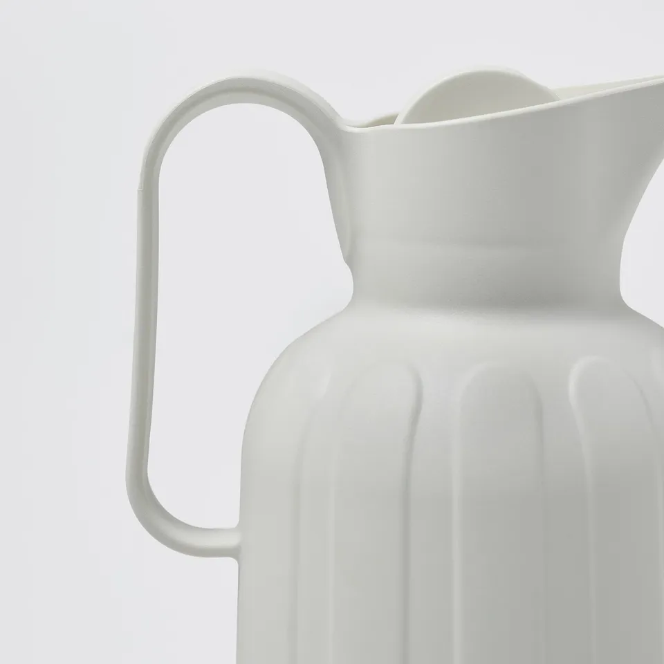 Close-up of white TAGGÖGA vacuum flask, showcasing sleek design and durable material.