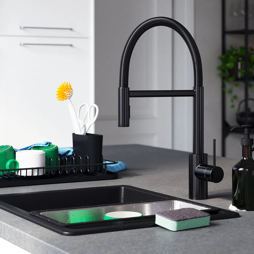 Modern kitchen with SALLSJÖN black tap and cleaning tools on grey countertop.