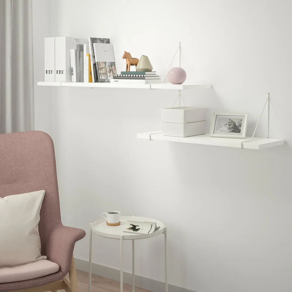 White BERGSHULT shelves with decor. Magazines, horse, vase, chair, coffee.