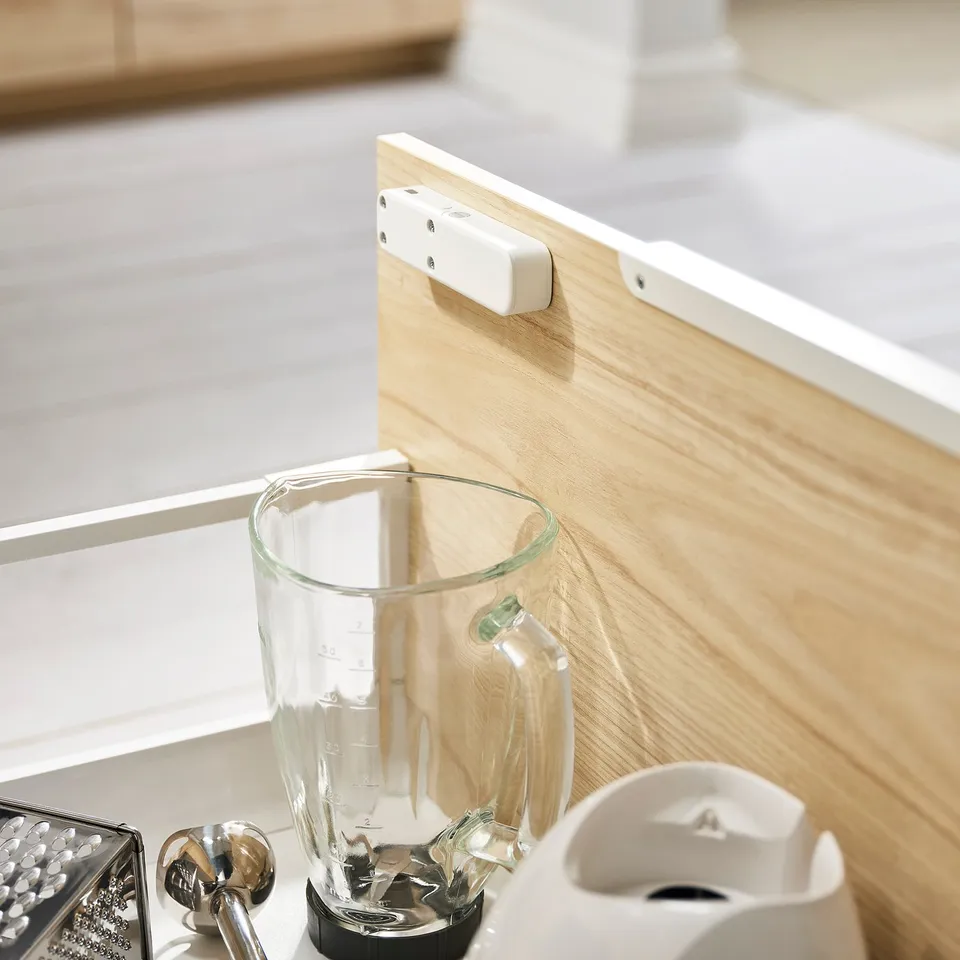 Wooden countertop with a clear blender jar, small grater, and a white kitchen gadget.